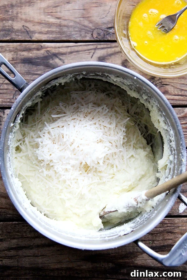 Roman Semolina Gnocchi Bake 4 Adding freshly grated Parmesan cheese to the thickened semolina mixture, enhancing the flavor of the gnocchi.