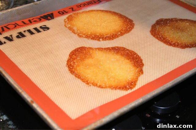Spiced Pumpkin Delight 3 Delicate tuile cookies baking to golden perfection on a non-stick silicone mat (silpat), ready to be shaped into elegant dessert bowls.