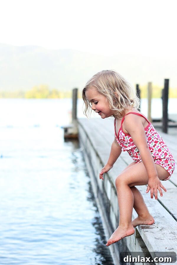 Lake George's pristine beauty awaits A picturesque view of Lake George with boats on the clear, blue water and lush green mountains in the background, signaling the start of a beautiful family vacation.