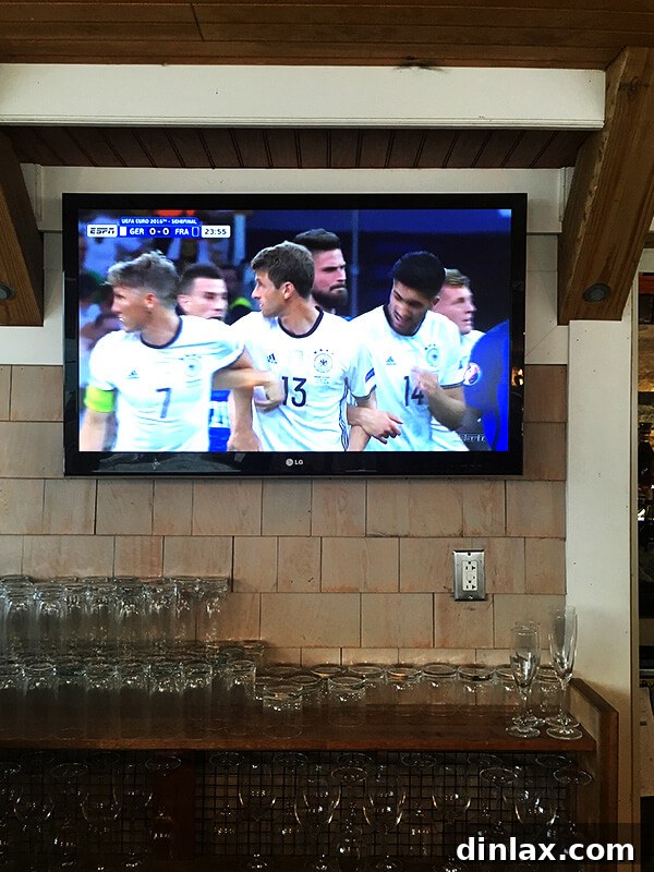 The Queen of American Lakes 17 A soccer match playing on a screen in a bar or restaurant, providing entertainment during a relaxed evening.