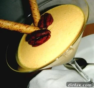 Velvet Pumpkin Panna Cotta 2 Creamy pumpkin panna cotta served in elegant martini glasses, garnished with candied pecans and hazelnut pirouette cookies.