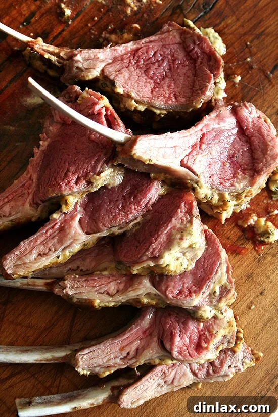 A beautiful board with perfectly sliced, succulent rack of lamb, featuring a golden herb crust.