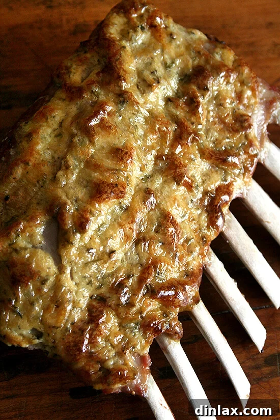 A beautifully cooked rack of lamb, resting peacefully on a wooden cutting board, crucial for juicy results.