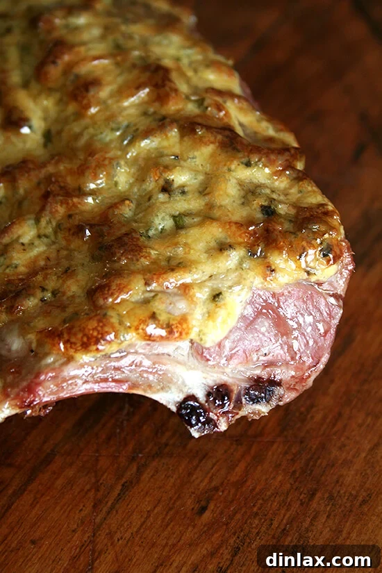 Close-up of a perfectly cooked rack of lamb, showcasing its tender meat and crispy herb crust, ready for carving.
