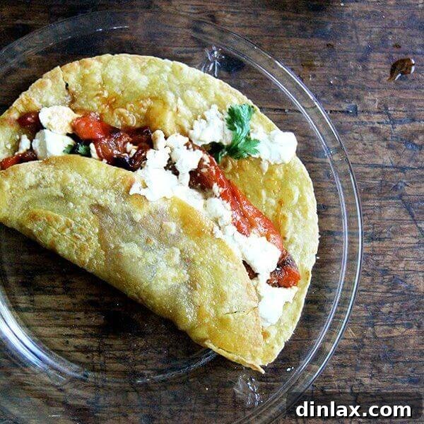 A vibrant roasted red pepper and white bean hummus wrap, featuring soft tortillas and fresh herbs.