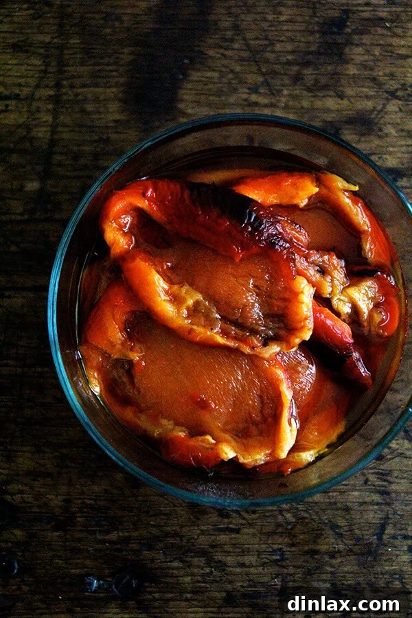 Peeled, deseeded, and sliced roasted red peppers, showcasing their vibrant color and tender texture, ready for use in wraps.