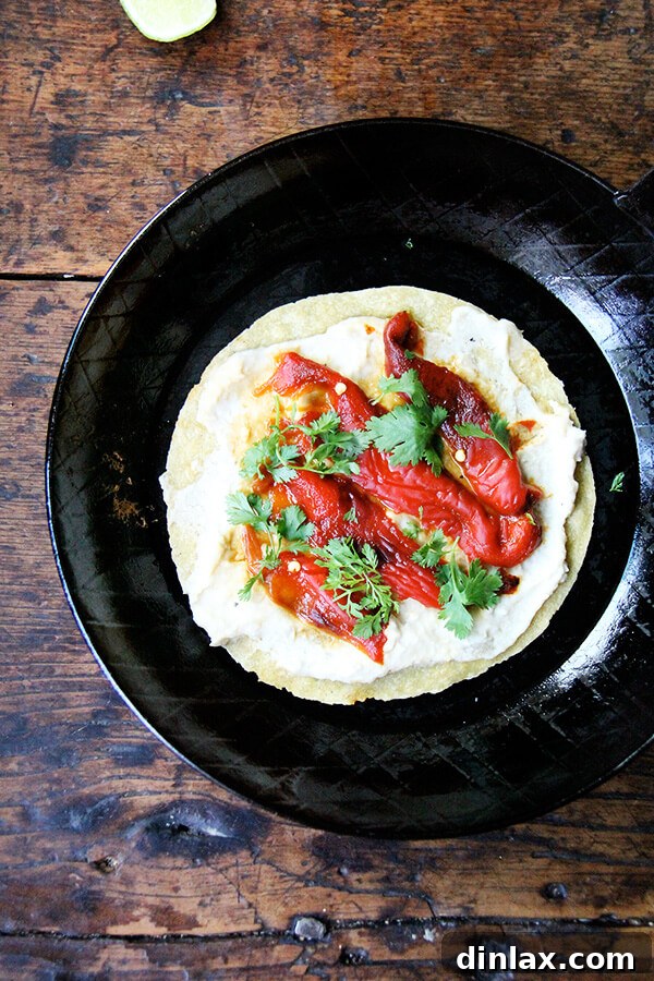 A beautifully assembled roasted red pepper and white bean hummus wrap, ready to be enjoyed as a light and healthy meal.