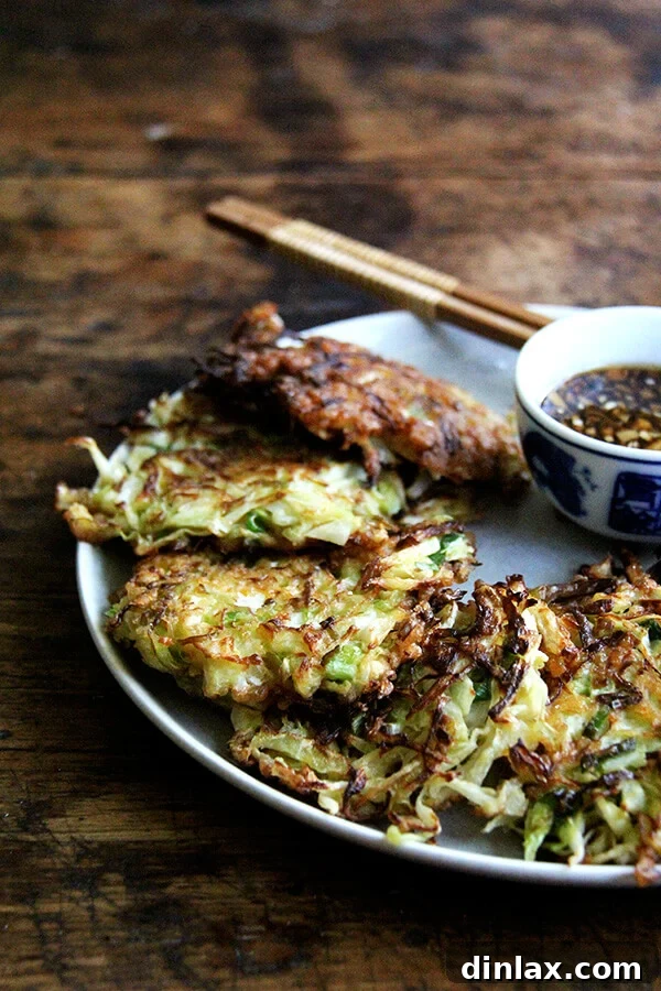 A platter of golden-brown Okonomiyaki pancakes, ready to be served with dipping sauce.