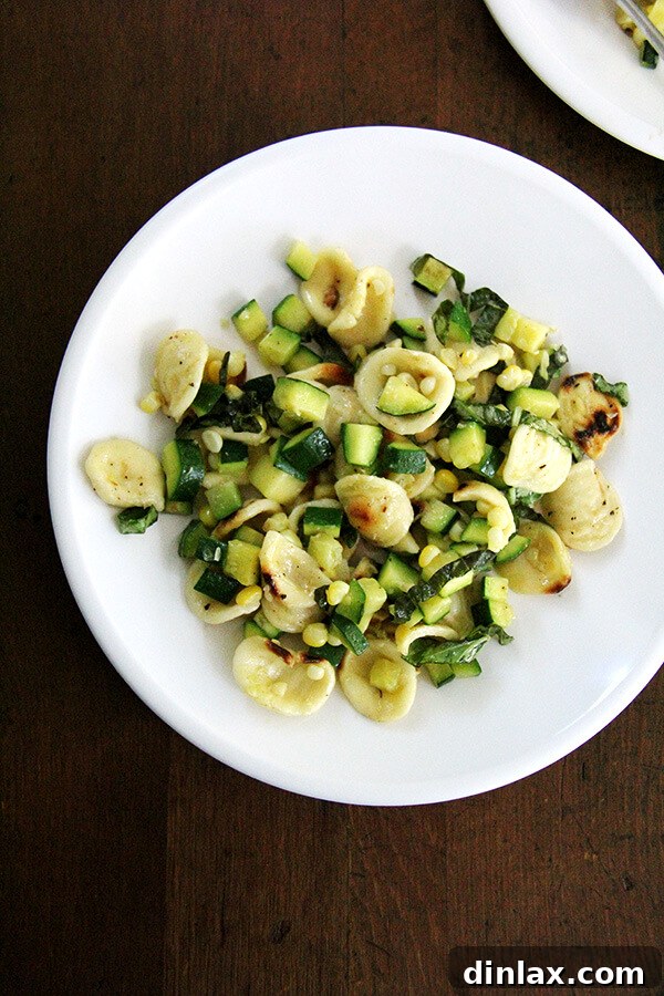 Fresh Zucchini and Corn Pasta A beautifully plated bowl of toasted orecchiette pasta with sautéed zucchini and fresh corn, garnished with basil, ready to be enjoyed.