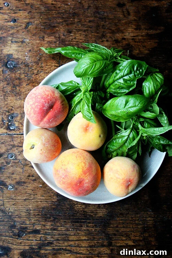 Close-up of fresh, ripe peaches sliced and vibrant green basil leaves, ready to be assembled into a delicious summer pizza.