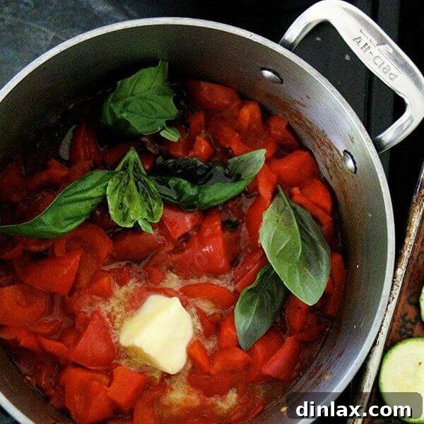 Rich homemade red pepper tomato sauce in a bowl, garnished with fresh basil.