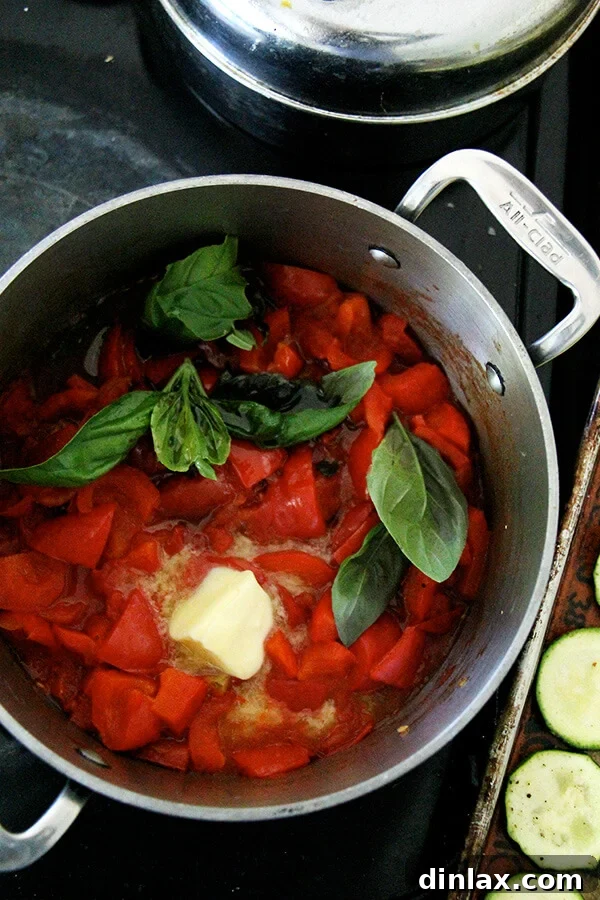 Red pepper and tomato sauce simmering in a pot, ready for pureeing.