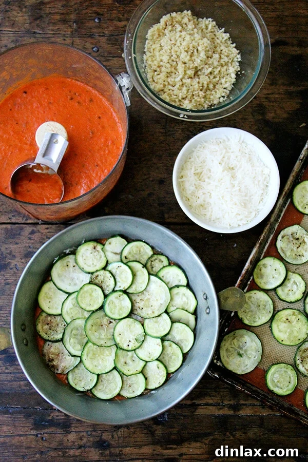 Assembling layers of roasted zucchini, sauce, and Parmesan cheese in a gratin dish.