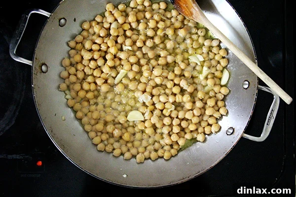 Mediterranean Chickpea and Tomato Stew with Feta 2 A sauté pan with fragrant garlic and chickpeas sizzling in golden olive oil, ready for the next step of the stew.