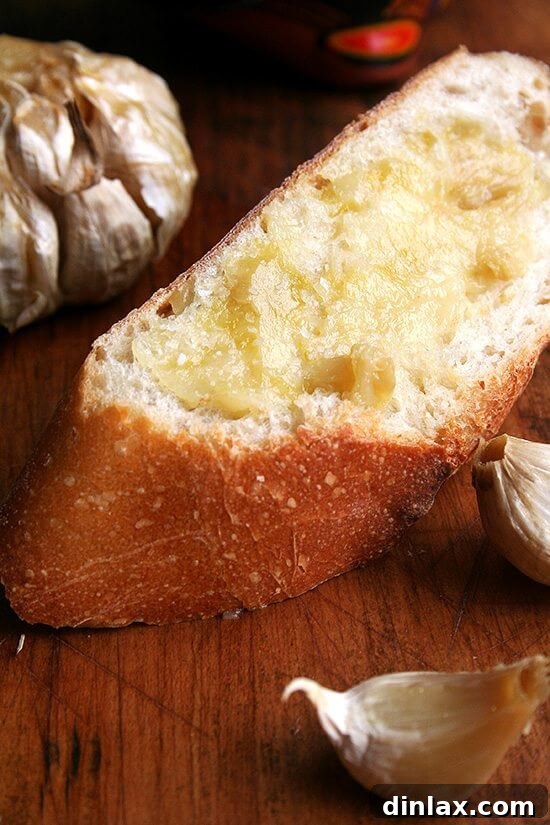 A close-up shot of toasted bread slices generously spread with tender roasted garlic cloves and a sprinkle of vibrant sea salt, ready to be eaten.