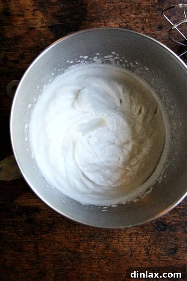 A stand mixer bowl featuring perfectly whipped aquafaba, created from chickpeas cooked at home.