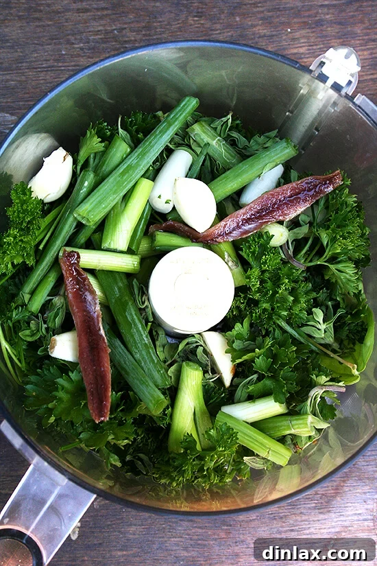 Salsa Verde Ingredients for Gratin Ingredients laid out for making fresh Salsa Verde: herbs, olive oil, garlic, anchovy, and capers.