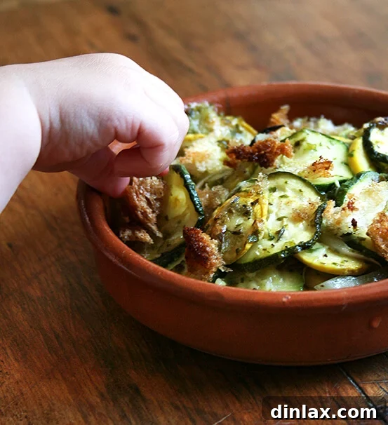 Sneaking a Bite of Gratin A child's hand reaching for a piece of the Summer Squash Gratin, caught in the act of sneaking a bite.