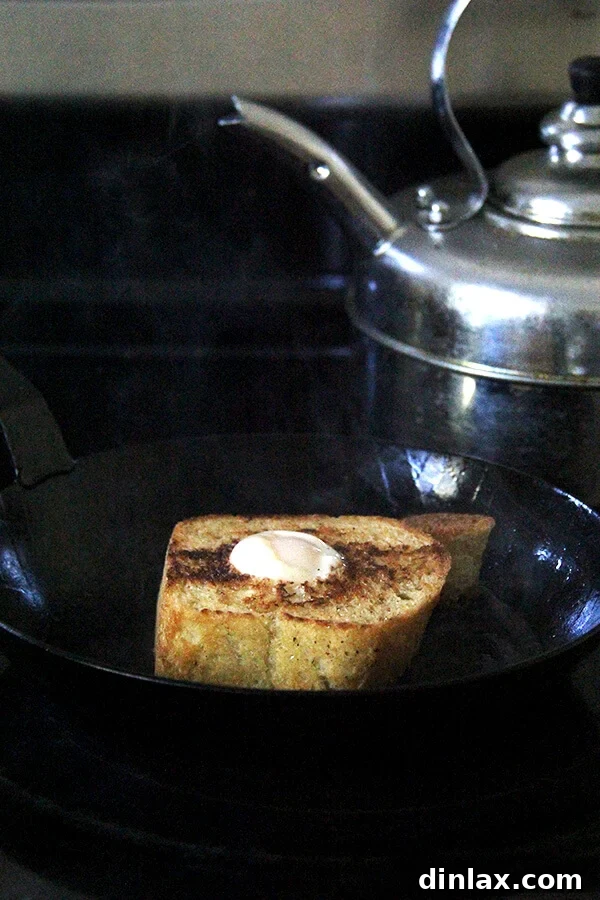 Sweet and Salty Marzipan Mandel Bread 13 Egg in a Hole cooking in a pan, with the egg perfectly set within the toasted bread.