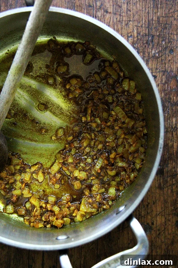 Golden Coconut Lentil Curry 3 Finely minced onions or shallots being sautéed in olive oil, forming the aromatic base for the curried lentils.
