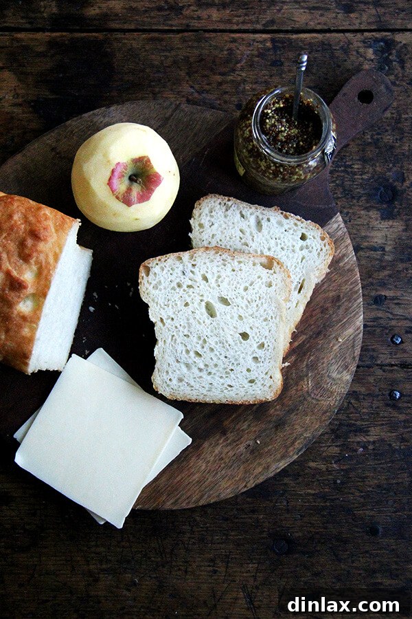 Ingredients laid out for grilled apple, cheddar, and mustard sandwich preparation.