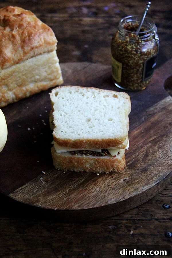 An assembled apple, cheddar, and mustard sandwich, ready for grilling.