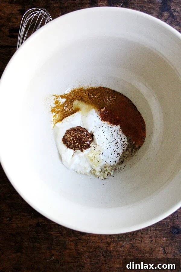 A close-up shot of the curried yogurt dressing being prepared, showcasing its creamy texture and rich yellow hue from the curry powder.