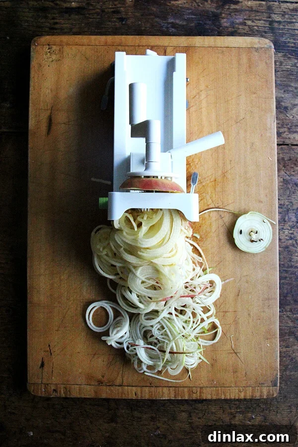 Crisp apple spirals, freshly cut, ready to be added to the egg salad, highlighting their elegant form and freshness.