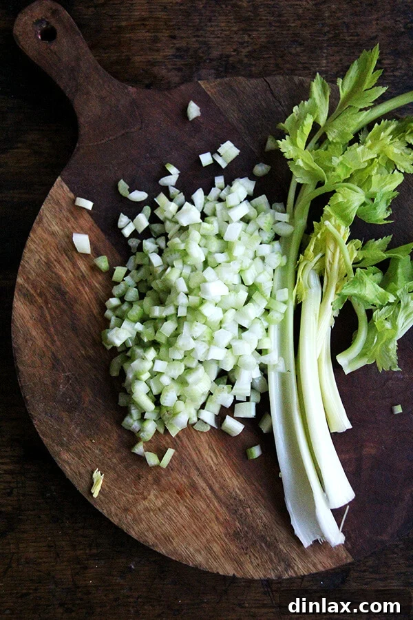 Finely diced celery, adding a fresh, aromatic crunch to the curried apple and egg salad, a key component for texture.