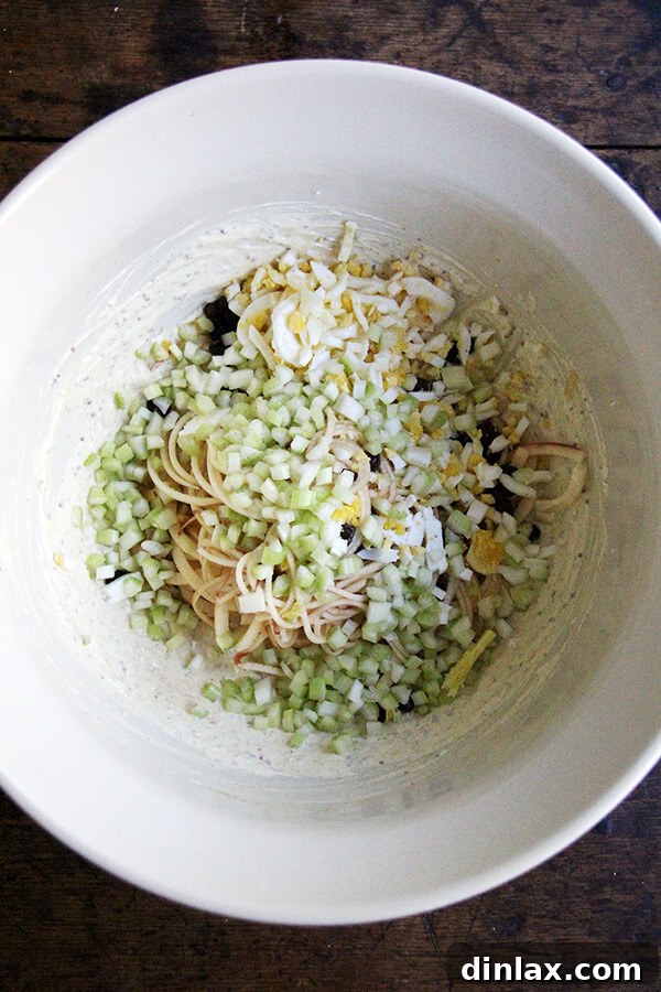 The finished curried apple-egg salad in a bowl, showcasing its creamy texture, colorful ingredients, and appealing presentation.