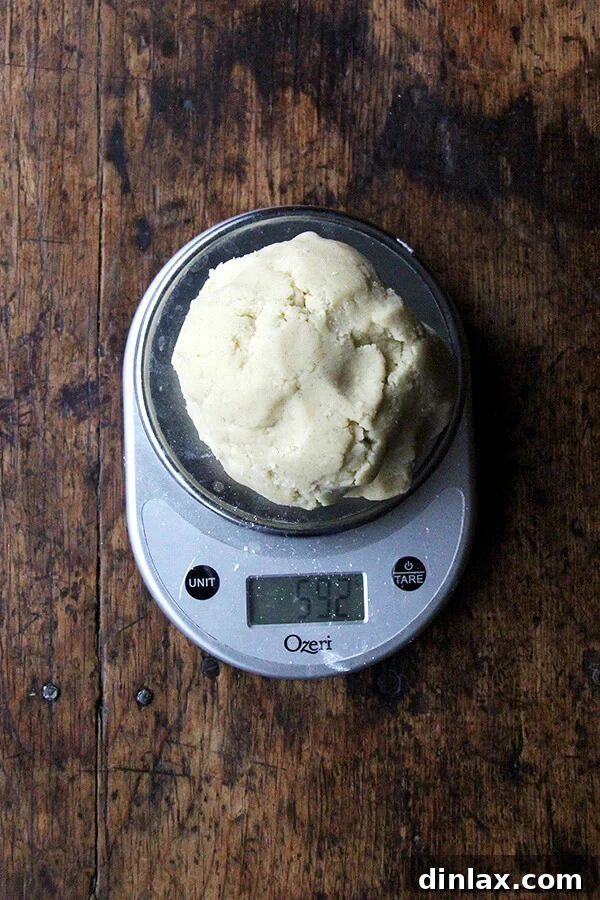 Dorie Greenspan's Classic Vanilla Bean Sablés 6 Sablé cookie dough being weighed on a kitchen scale for precise portioning.