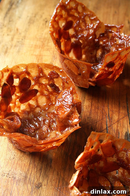 Almond-Butterscotch Cookie Cups Display An array of delicate almond butterscotch cookie cups cooling, ready to be filled with ice cream or other desserts.