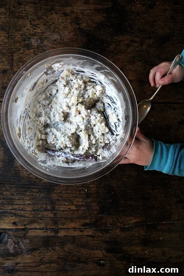 An inviting bowl of apple pie overnight oats with a spoon, ready to be eaten.