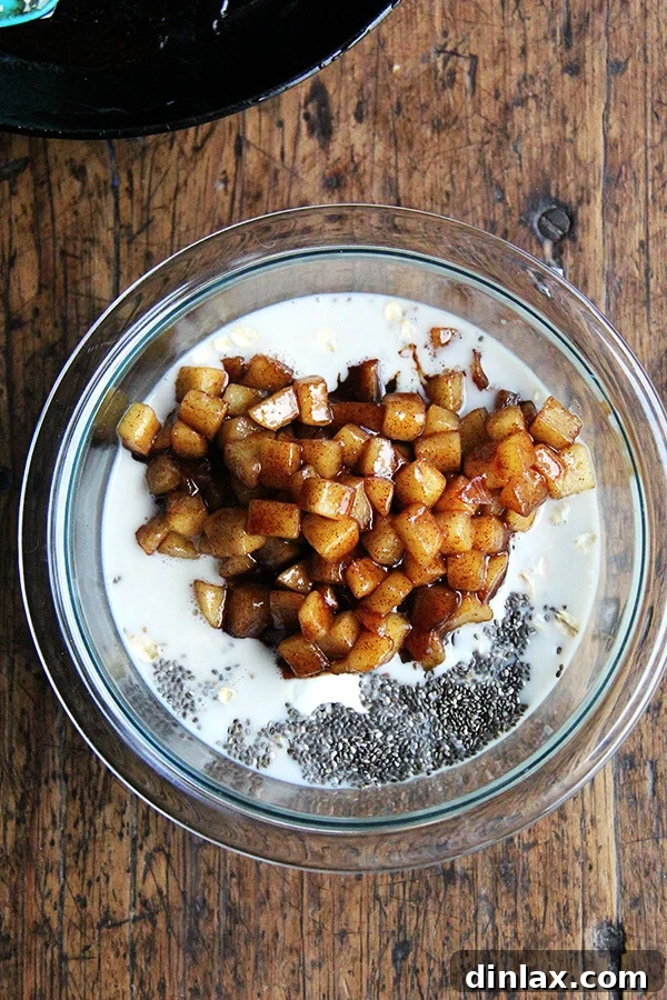 Diced apples sautéing in a skillet with cinnamon and maple syrup, caramelizing to perfection.