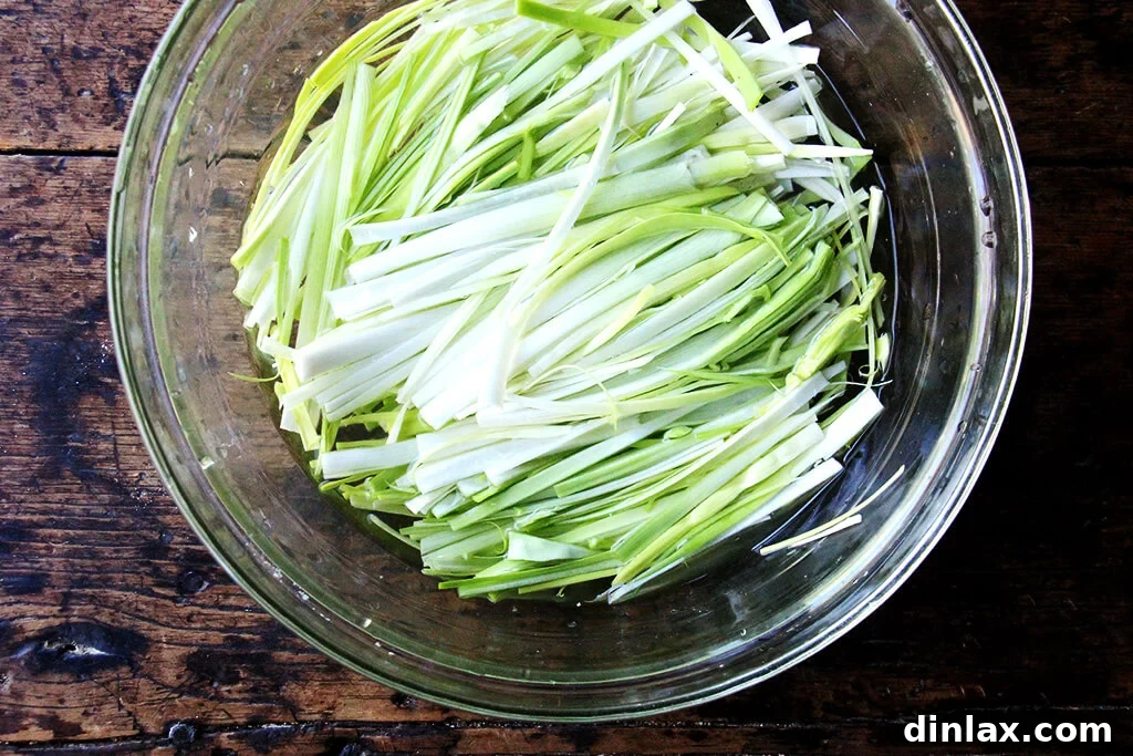 Sunny Lemon Leek Bucatini Skillet 3 Close-up view of sliced leeks, ready to be added to the one-pan pasta, showcasing their delicate rings.