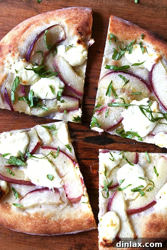 With the help of Marcella Hazan's homemade tomato sauce, classic pizza margherita can be achieved at home with delectable results. And thanks to the Barefoot Contessa, making homemade ricotta is easy and delicious. // alexandracooks.com A wider shot of the nectarine and ricotta pizza with fresh basil, offering a full view of its tempting appearance.