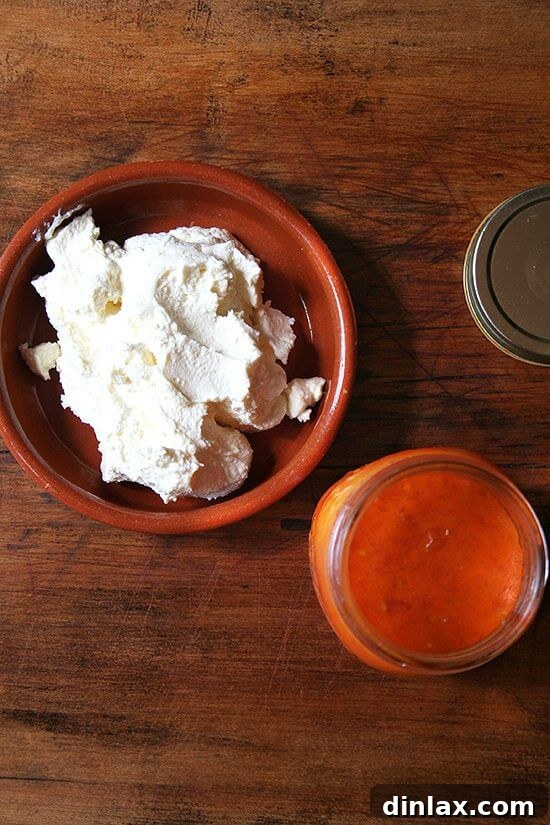 Classic Margherita Pizza with Marcella Hazan's Signature Tomato Sauce and House-Made Ricotta 9 A delightful display of two quart jars filled with rich, homemade tomato sauce next to a bowl of creamy, fresh ricotta cheese.