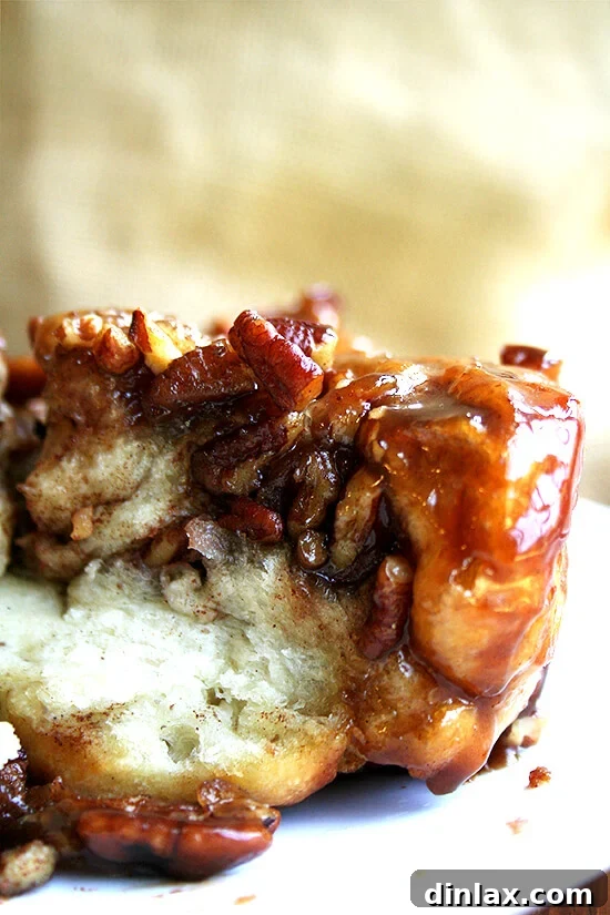 Sticky Pecan Caramel Rolls - Glistening Perfection Close-up of freshly baked sticky pecan caramel rolls, glistening with caramel and topped with pecans, ready to be served.