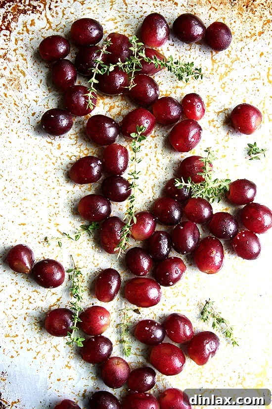 Fresh grapes tossed with fragrant thyme, rich olive oil, and a pinch of salt, ready for roasting to create a flavorful base for ricotta and grilled bread.