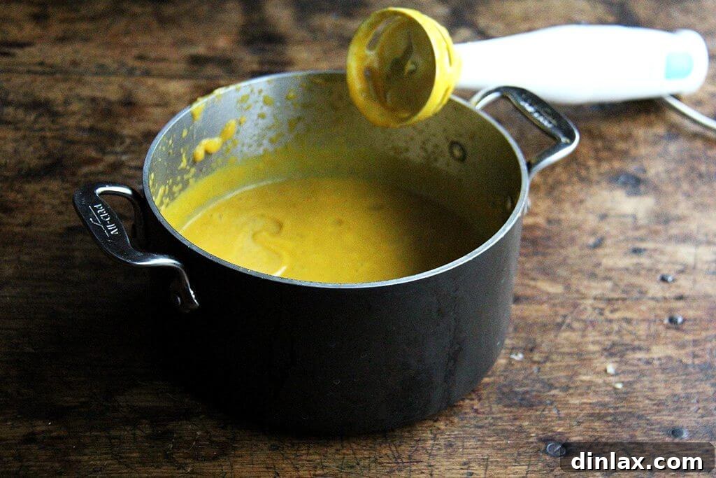Golden Butternut and Sage Penne Bake 5 A pot filled with a smooth, bright orange pureed butternut squash-sage sauce, ready for the pasta.
