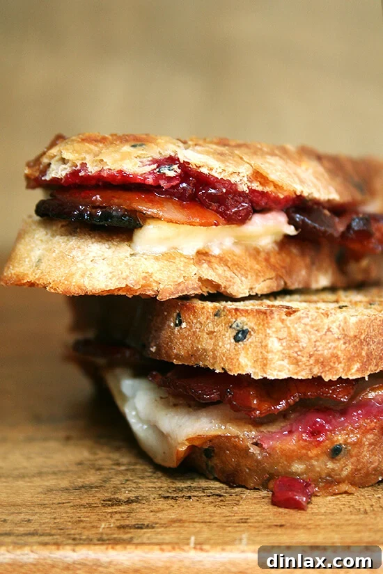 Close-up of a perfectly grilled bacon, cheddar, and pear panini, sliced in half