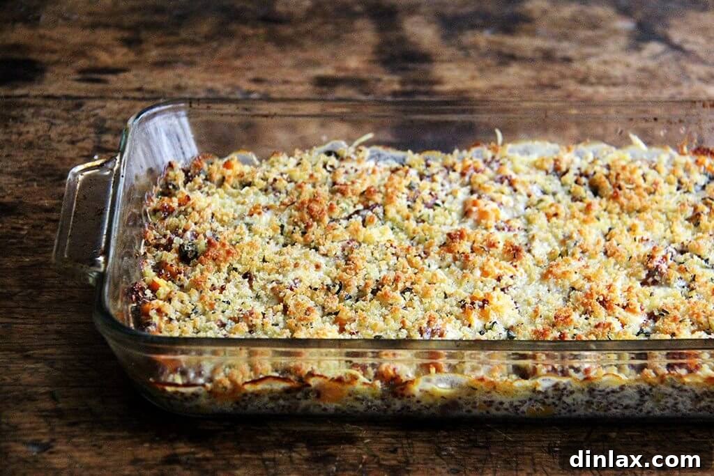 A 9x13-inch baking pan, fresh out of the oven, showcasing the golden-brown, bubbling quinoa bake with roasted butternut squash and onions, its top perfectly crisped.