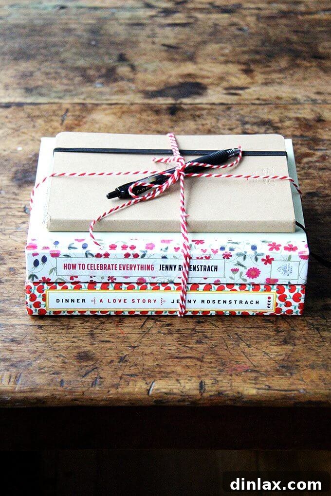 Alexandra Stafford, interviewer, showcasing Jenny Rosenstrach's books and a notebook for the giveaway.