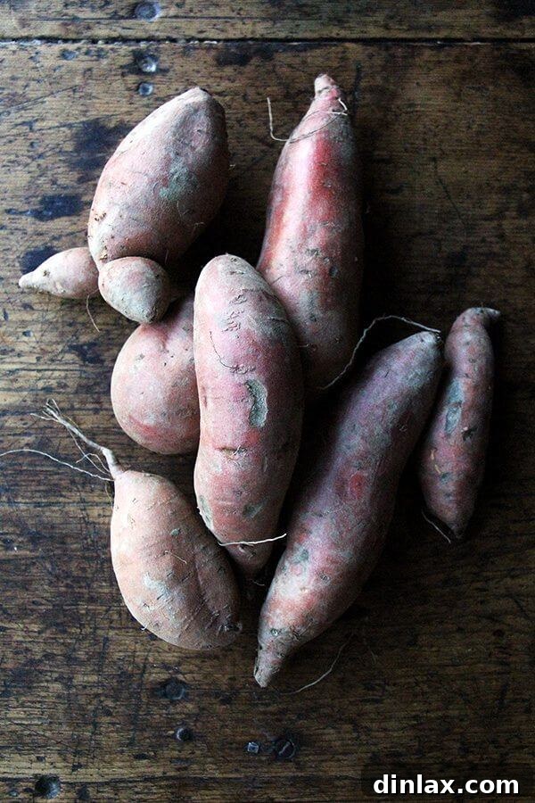Raw sweet potatoes on a cutting board, ready to be prepared for frying.