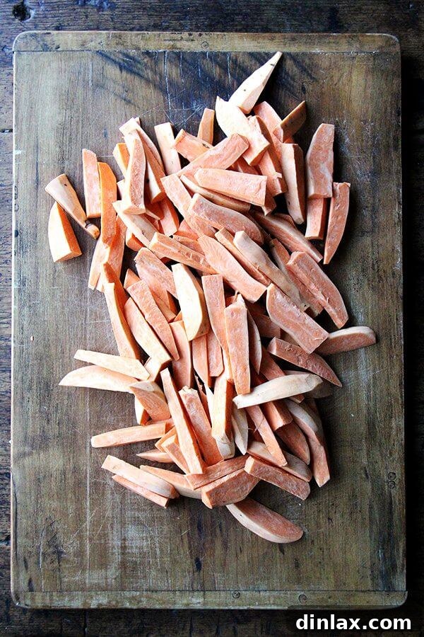 Sweet potatoes freshly cut into thick wedges, demonstrating the ideal size for frying.