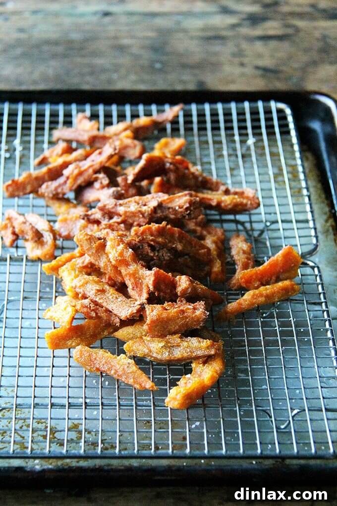 A generous tray of freshly fried thick-cut sweet potato fries, golden and inviting.