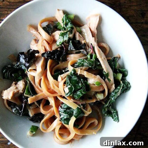 A bowl of sesame noodles with swiss chard.