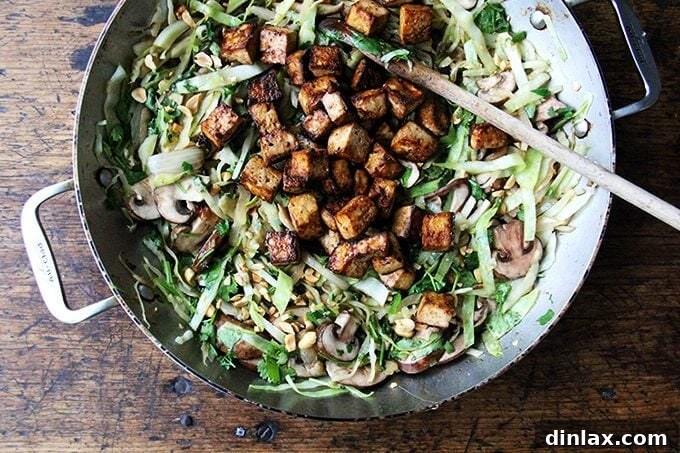 Stir-frying cabbage with other vegetables in a large pan for the Pad Thai-ish dish.