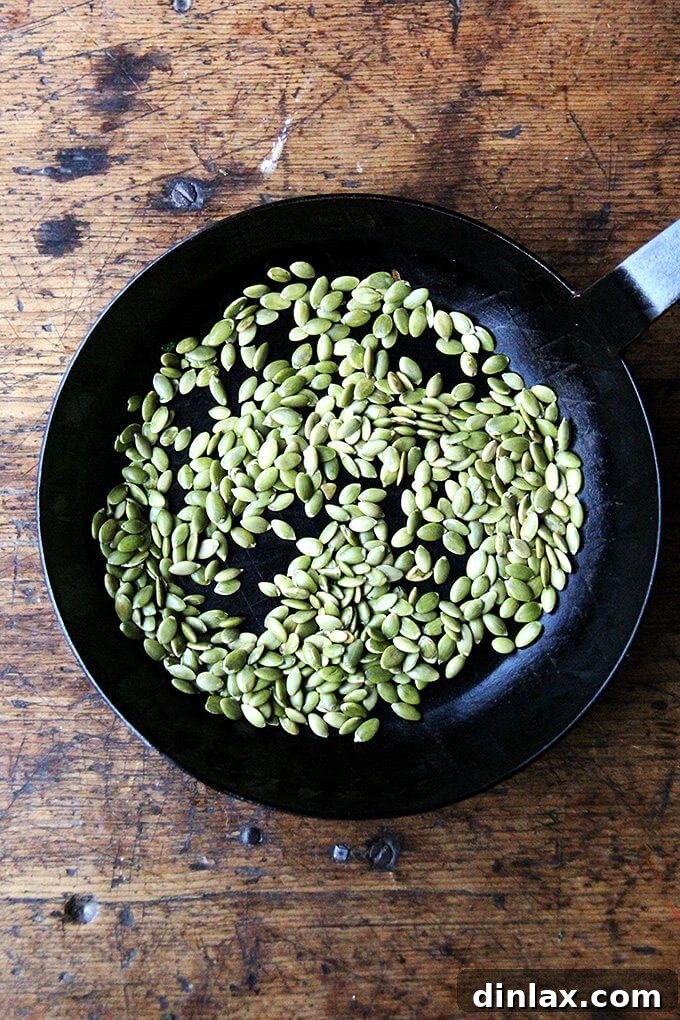 Toasted pumpkin seeds cooling on a plate, ready to be puréed for the salad dressing.
