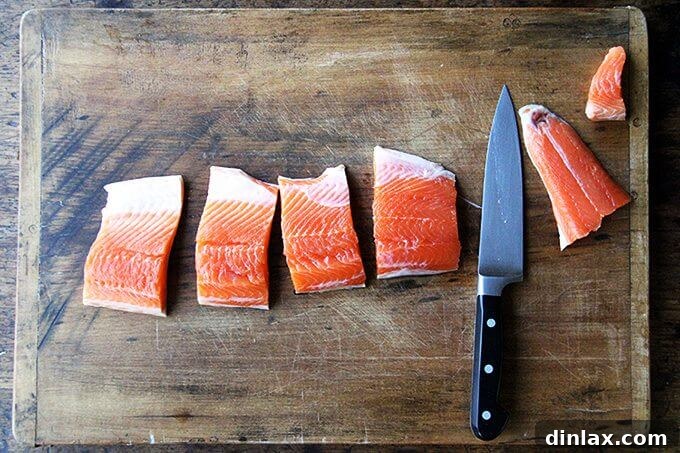 Raw Arctic Char fillets expertly cut and arranged on a wooden board.